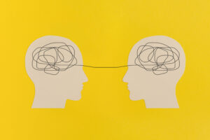 Human heads with gears on yellow background